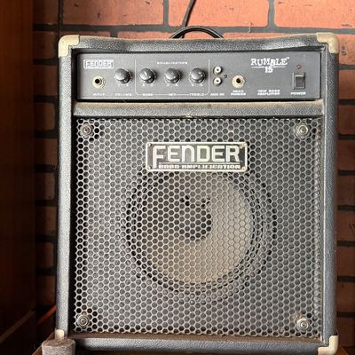 Sale Photo Thumbnail #180: Fender Rumble 15 bass amplifier featuring a black textured vinyl cabinet, front metal grille, and control panel with equalization knobs.