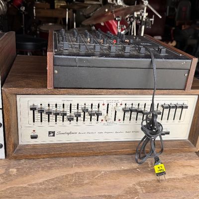 Sale Photo Thumbnail #182: Vintage Soundcraftsmen Model RP2212 audio equalizer in a wood cabinet, alongside a audio mixer console and additional stereo equipment components.