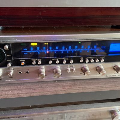 Sale Photo Thumbnail #195: Vintage Pioneer QX-949 quadraphonic stereo receiver, featuring a wood-grained case, illuminated blue tuner dial, and built-in oscilloscope, circa 1970s.