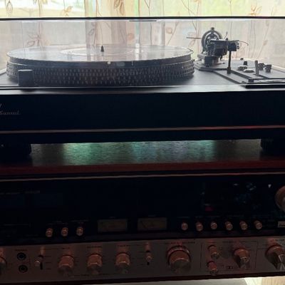 Sale Photo Thumbnail #198: Vintage Sansui turntable with clear dust cover sitting atop a matching Sansui stereo receiver with wood cabinet.