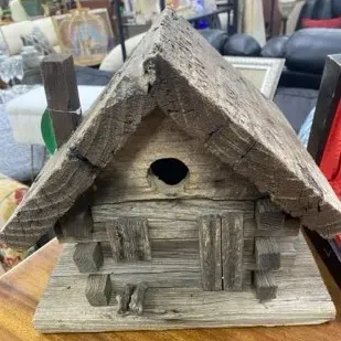 Sale Photo Thumbnail #30: Handcrafted rustic wooden log cabin birdhouse featuring weathered timber construction, a chimney, and a small entry hole.
