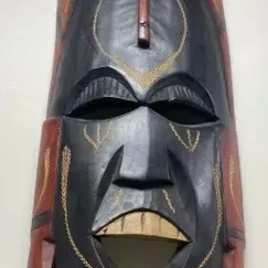 Sale Photo Thumbnail #42: Hand-carved African style elongated wooden mask featuring black and terracotta hand-painted finish with incised yellow geometric detailing.