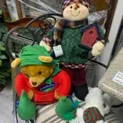 Sale Photo Thumbnail #46: Collection of plush holiday figures featuring a Winnie the Pooh stuffed animal, a standing fabric snowman holding a birdhouse, and a plush polar bear.