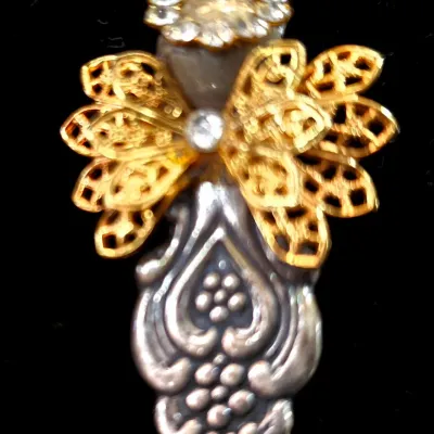 Sale Photo Thumbnail #76: Handcrafted silver-tone and gold-tone angel pendant or brooch made from repurposed flatware handles and filigree elements, accented with rhinestones.