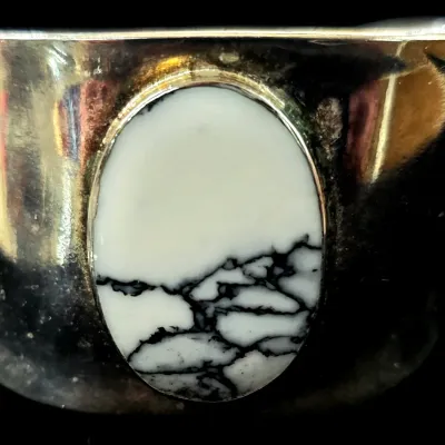 Sale Photo Thumbnail #80: Native American style silver cuff bracelet set with a large oval white buffalo stone featuring dark matrixing.