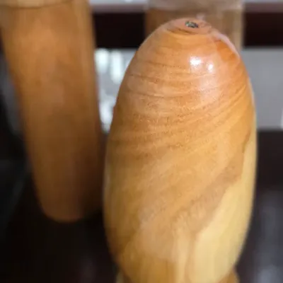 Sale Photo Thumbnail #100: Hand-turned wooden salt or pepper shaker featuring a distinct, polished natural wood grain.