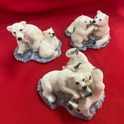 Sale Photo Thumbnail #141: Set of three molded resin polar bear family figurines on faux stone bases, depicting adult bears and cubs in play.