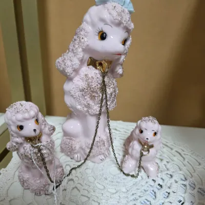 Sale Photo Thumbnail #156: Vintage 1950s California Creations by Bradley pink ceramic spaghetti poodle family with chain leash, featuring gold accents and a blue crown on the mother dog.