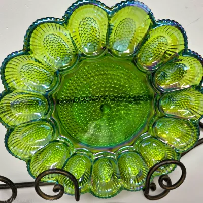 Sale Photo Thumbnail #172: Vintage iridescent green carnival glass deviled egg platter with hobnail textured accents and a scalloped rim.