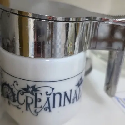 Sale Photo Thumbnail #192: Vintage white milk glass syrup dispenser with a chrome-plated lid and handle, featuring stylized navy lettering.