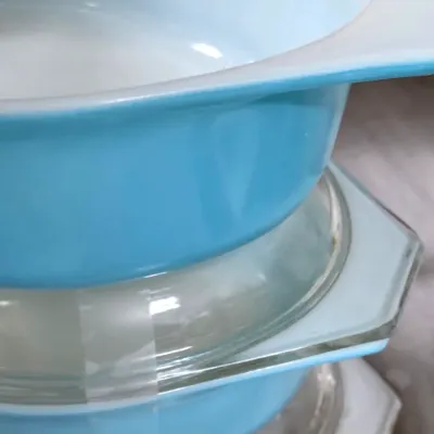 Sale Photo Thumbnail #211: Stack of vintage Pyrex casserole dishes in turquoise and patterned finishes, complete with clear glass lids.