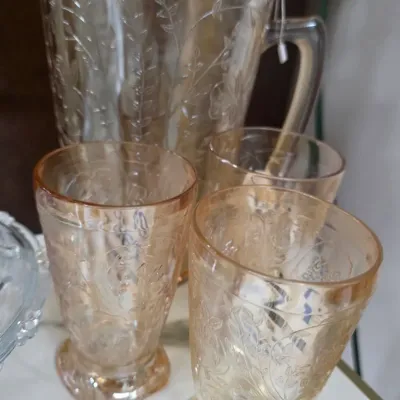 Sale Photo Thumbnail #216: Vintage amber Depression glass water pitcher and matching tumblers featuring an etched floral and vine pattern.