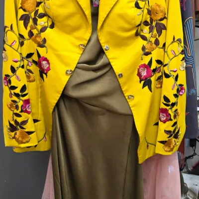 Sale Photo Thumbnail #278: Vibrant yellow fitted blazer with elaborate floral embroidery paired with an olive green draped dress and tiered pink tulle accents. Features an Alley Theatre costume tag.