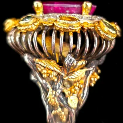 Sale Photo Thumbnail #287: Intricate statement cocktail ring featuring an ornate two-tone basket setting with a large pink gemstone and accent stones.