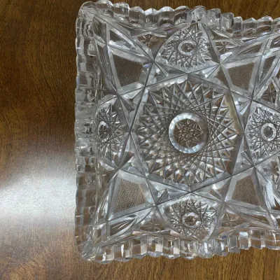 Sale Photo Thumbnail #294: American Brilliant Period cut glass square dish featuring intricate starburst and geometric pinwheel patterns with scalloped edges.