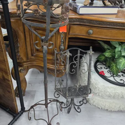 Sale Photo Thumbnail #314: Vintage wrought iron plant stand with grapevine detailing alongside a small fleur-de-lis decorated metal wall shelf.