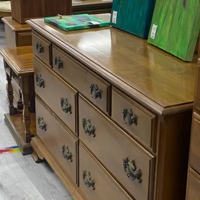 Sale Photo Thumbnail #326: Traditional wooden double dresser with eight drawers featuring decorative brass bail handles and ornate trim detail.