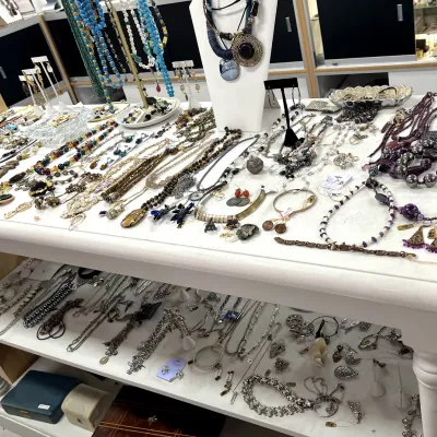 Sale Photo Thumbnail #403: Large collection of vintage and contemporary fashion jewelry displayed across multiple shelves, featuring beaded necklaces, statement pendants, bracelets, and earrings.