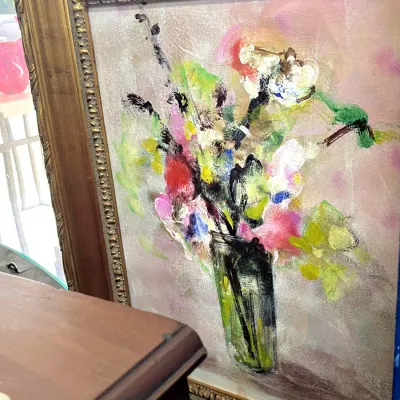 Sale Photo Thumbnail #404: Framed impressionist oil painting depicting a floral still life in a glass vase, housed in an ornate wood frame with carved details.