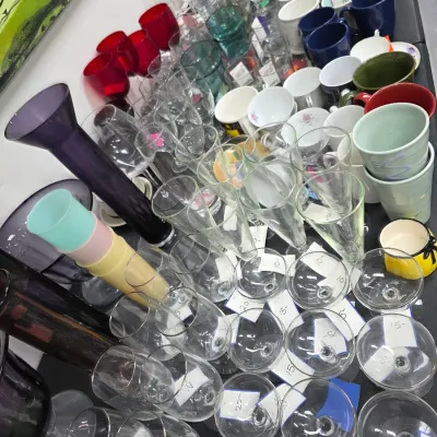 Sale Photo Thumbnail #419: Large assortment of glassware and ceramics, including wine glasses, champagne flutes, coffee mugs, and decorative vases.