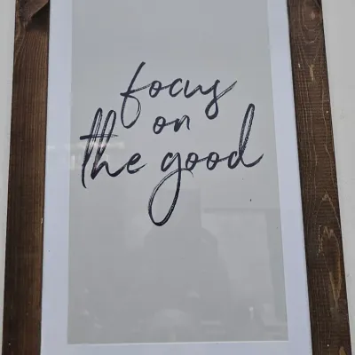 Sale Photo Thumbnail #439: Framed inspirational wall art featuring the phrase 'focus on the good' in cursive typography, set in a dark rustic wood frame.