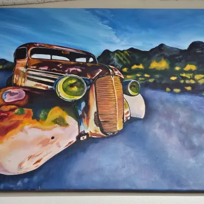 Sale Photo Thumbnail #440: Large acrylic canvas painting of a vintage rusty truck set against a desert landscape backdrop, signed by artist Kelly Spell.