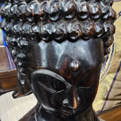 Sale Photo Thumbnail #457: Hand-carved dark wood Buddha head sculpture featuring detailed coiled hair and serene facial expression.