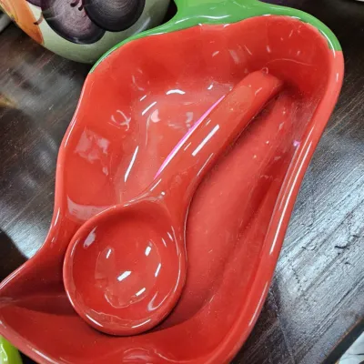 Sale Photo Thumbnail #475: Chili pepper-shaped glazed ceramic salsa dish with matching red ladle, featuring a green stem accent.