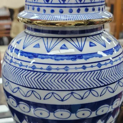 Sale Photo Thumbnail #494: Blue and white patterned ceramic ginger jar topped with a metallic gold finial lid.