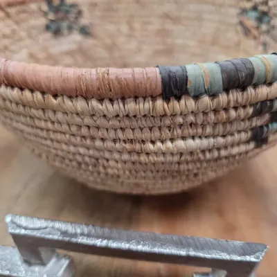 Sale Photo Thumbnail #500: Hand-woven coiled basket featuring a multicolor wrapped rim in shades of dusty rose, sage green, and dark grey.