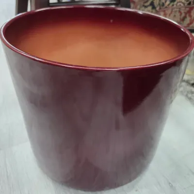 Sale Photo Thumbnail #501: Large glossy deep red ceramic planter pot featuring an unglazed terracotta interior.