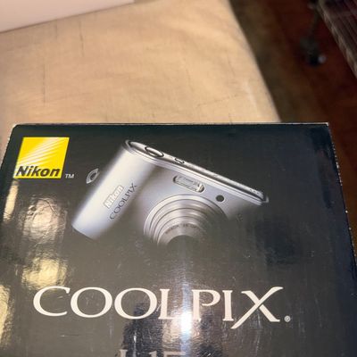 Sale Photo Thumbnail #29: Nikon Coolpix L15 digital camera in its original retail box, circa late 2000s.