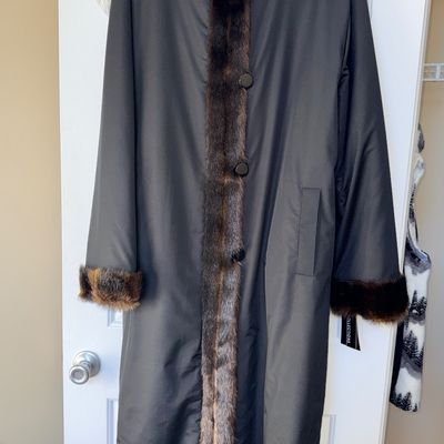Sale Photo Thumbnail #36: Full-length black coat featuring faux fur trim along the placket, collar, and cuffs with large front button closures.
