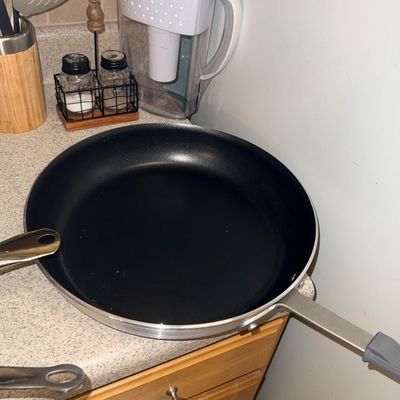 Sale Photo Thumbnail #73: Large nonstick skillet resting on a kitchen countertop alongside salt and pepper shakers and a Brita water filter pitcher.