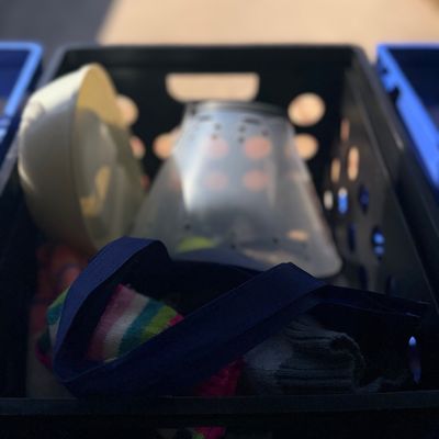 Sale Photo Thumbnail #98: Black plastic crate filled with assorted household items, including a clear lampshade, a bowl, and fabric materials.