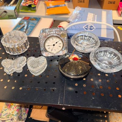 Sale Photo Thumbnail #203: Collection of decorative lead crystal accessories, including a square desk clock, small bowls, covered trinket dishes, a butterfly paperweight, and a vintage black musical trinket box.