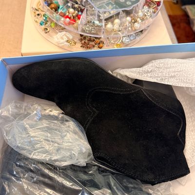Sale Photo Thumbnail #215: Black suede Antonio Melani ankle boots in their original shoe box, alongside a rotating acrylic jewelry organizer filled with assorted costume jewelry.