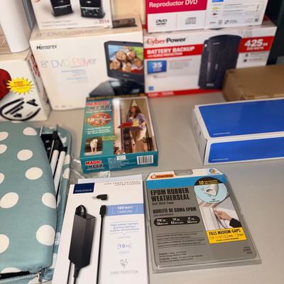 Sale Photo Thumbnail #296: Collection of boxed electronics and household items, including an Insignia universal laptop charger, Frost King weatherseal tape, CyberPower battery backup, and Memorex DVD player.
