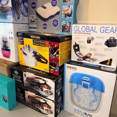 Sale Photo Thumbnail #303: A collection of boxed household items and personal care products, including a HoMedics foot spa, Vasconia pressure cooker, and a Perfect Cushion seat cushion.