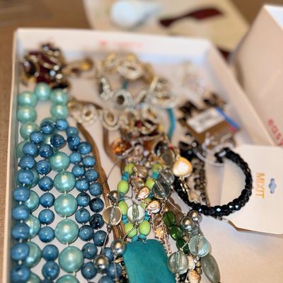 Sale Photo Thumbnail #331: Box filled with assorted costume jewelry, including beaded necklaces in shades of blue and green, statement pieces, and various bracelets.