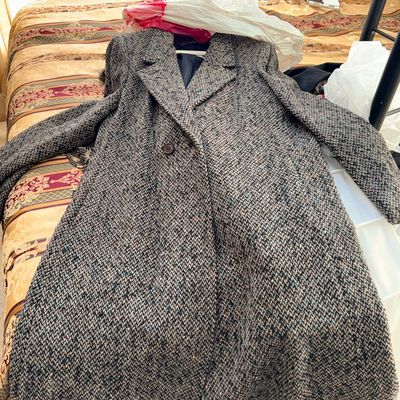 Sale Photo Thumbnail #335: Vintage heavy tweed wool overcoat in a grey and brown herringbone weave, laid out on a patterned bedspread.