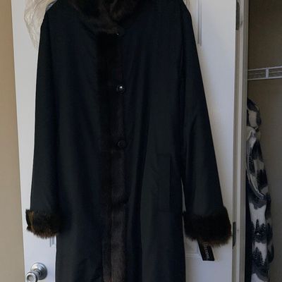 Sale Photo Thumbnail #339: Full-length black coat featuring faux-fur trim on the collar, cuffs, and front placket, hanging from a door in pristine condition.
