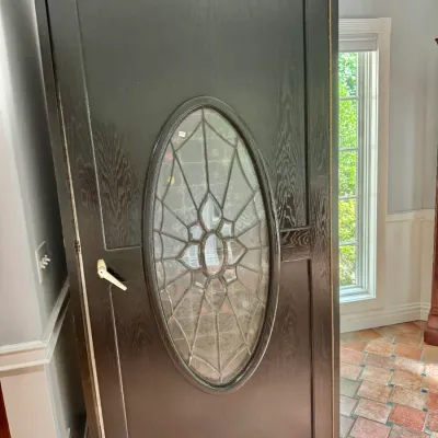 Sale Photo Thumbnail #20: LARGE WINE REFRIG - Dark espresso wooden exterior door featuring an oval decorative leaded glass insert and silver handle.