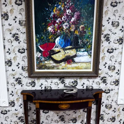 Sale Photo Thumbnail #30: Framed impasto oil painting depicting a floral still life with a violin, displayed above a mahogany console table with inlaid details.