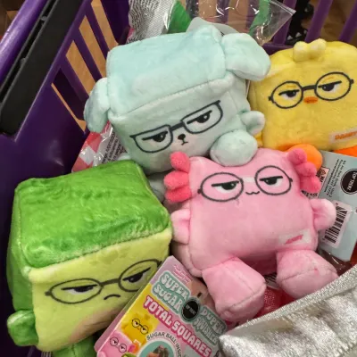 Sale Photo Thumbnail #71: Collection of Top Trenz Super Sugar Duper Squisher Total Squares plush toys inside a purple shopping basket.