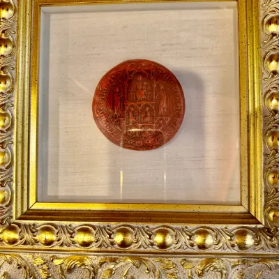 Sale Photo Thumbnail #86: Framed red wax seal impression depicting religious figures, shadow-boxed against a silk backdrop in an ornate gilt frame.