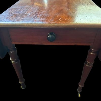 Sale Photo Thumbnail #125: 42"W (leaves) / 24"W (no leaves) × 45"L × 29"T Vintage Solid Wood Drop-Leaf Dining Table  features two fold-down end leaves and tapered legs and silverware drawer. Measurements: 42" wide w/leaves  24" w/o leaves  45" length  29" tall. Local  .  