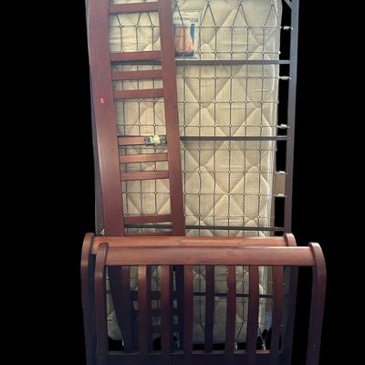 Sale Photo Thumbnail #214: Twin daybed set featuring rich warm wood frame with arched slat sides  metal link spring support frame  and Sealy Posturepedic mattress.  