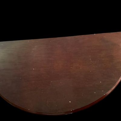 Sale Photo Thumbnail #253: 29"T × 24"W × 12"D Half-moon demilune accent table in rich mahogany finish featuring smooth curved apron  central floral brass medallion detail  and three slender splayed cabriole-style legs. Dimensions: 29" Tall x 24" Wide x 12" Deep.  
