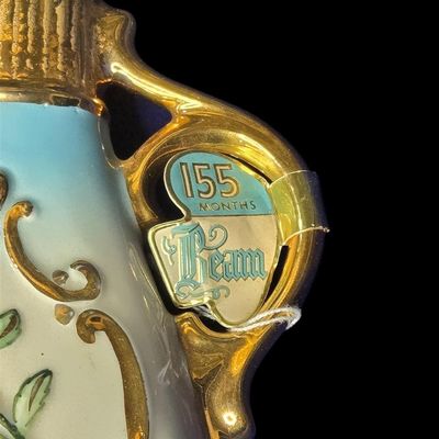 Sale Photo Thumbnail #445: Vintage 1960s Jim Beam Regal China porcelain decanter (155 Months Old series) designed by C. Miller. Features raised hand-painted pink rose floral motifs, rich 22K gold leaf gilded accents on the neck, handle, and base, with a weeping gold stopper. Includ